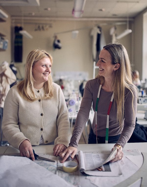 Elev och lärare kollar på designskisser