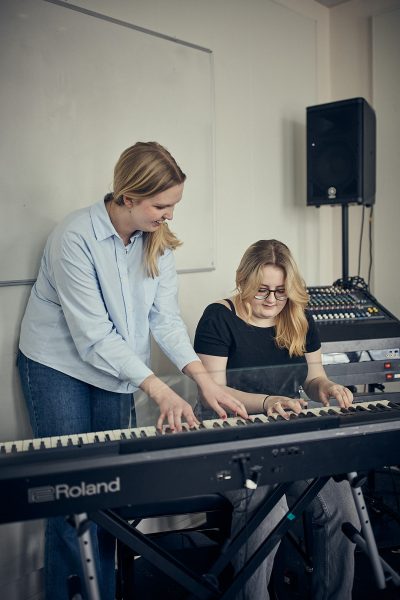 Lärare och elev spelar piano