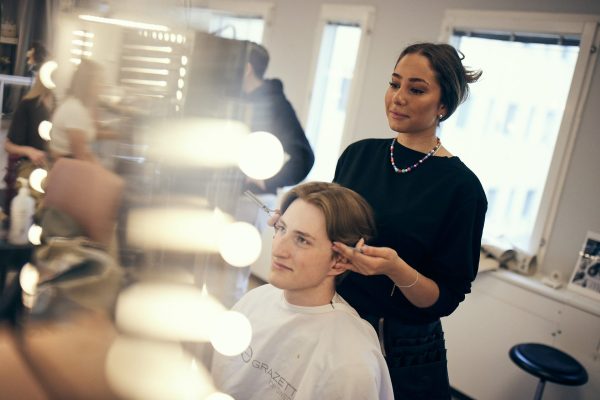 Elev visar upp en fixad frisyr för sin kund