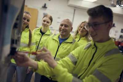 Lärare och elever i grupp med gula jackor