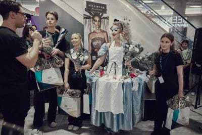 Tävlande tar emot pokal tillsammans med sin modell.