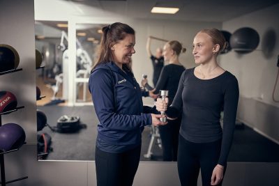 Elever och lärare tränar i ett gym