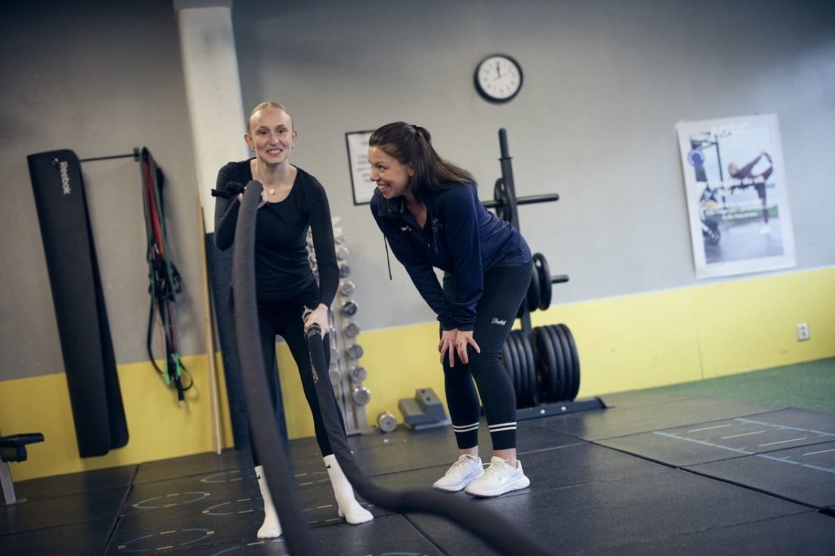 Två elever tränar i ett gym