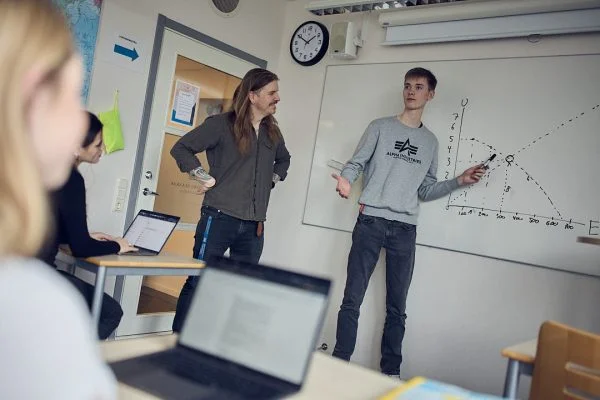 Lärare och elev står framme vid tavlan