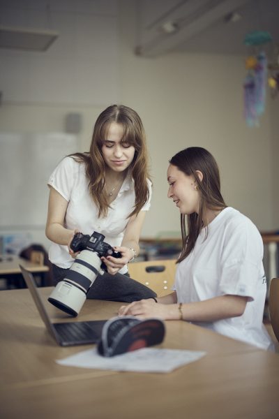 Lärare och elev tittar på bilder de tagit med en kamera