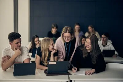 Tre elever får hjälp av en lärare
