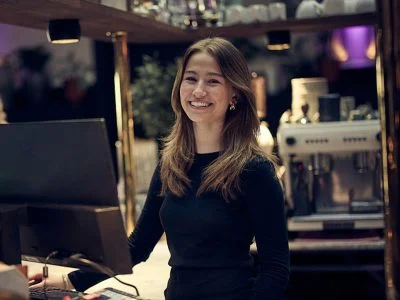 Glad elev står vid en dator i en reception