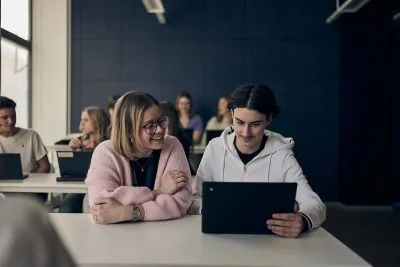 Lärare hjälper elev framför en dator