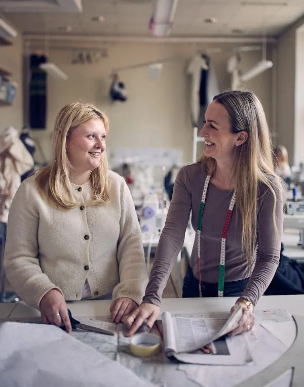 Elev och lärare kollar på designskisser