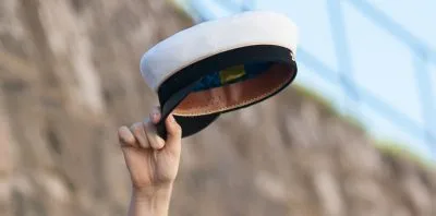 En hand som håller i en studentmössa