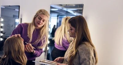 Elever sminkar en kund