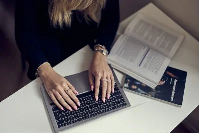 Närbild på elevs händer som skriver på en dator