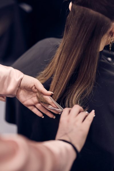 Närbild på en elev som klipper hår