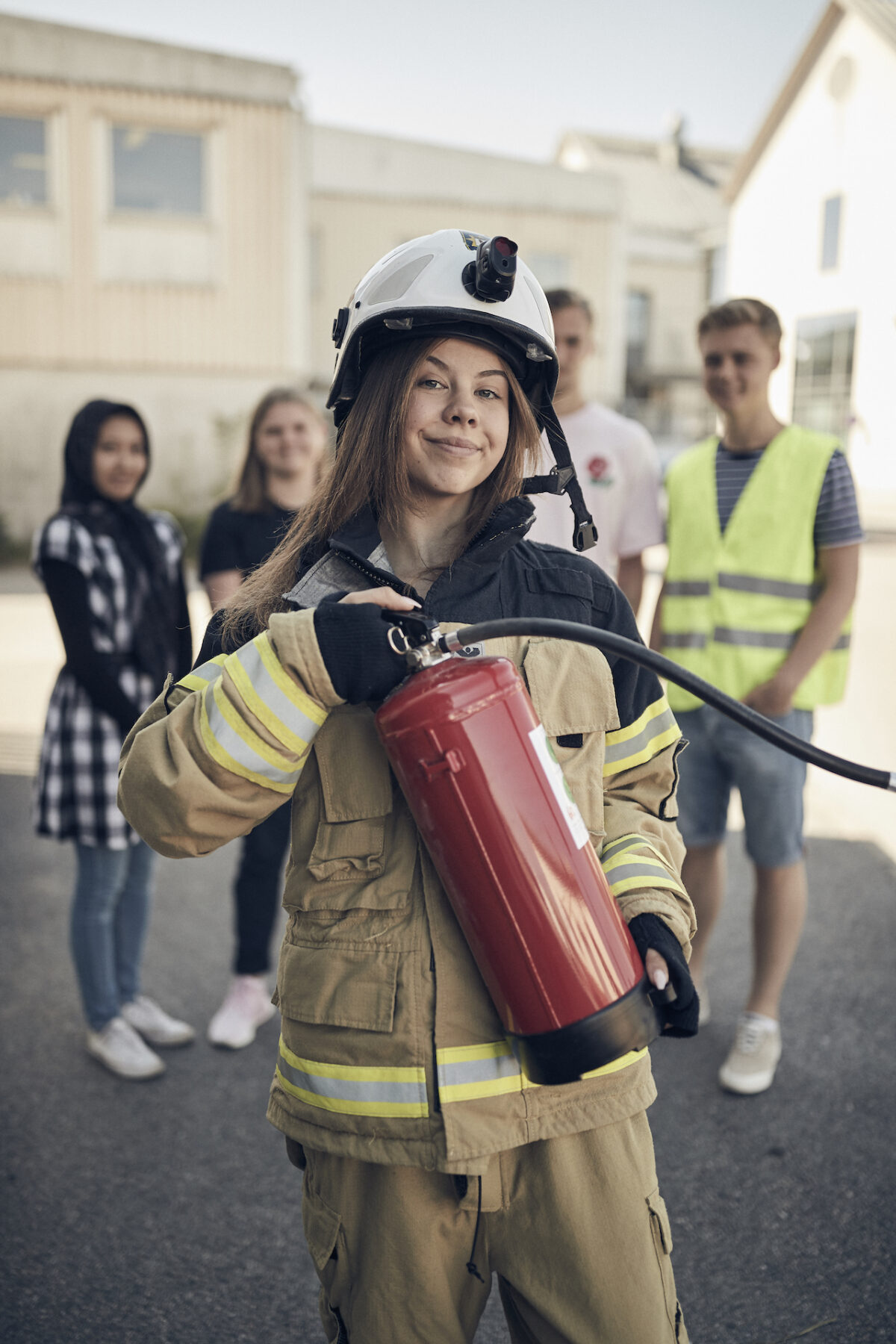 Elev i branduniform håller en brandsläckare
