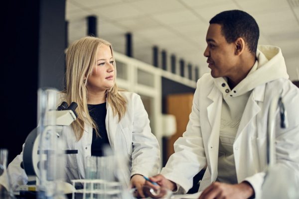 Elever i en labbsal med vita rockar