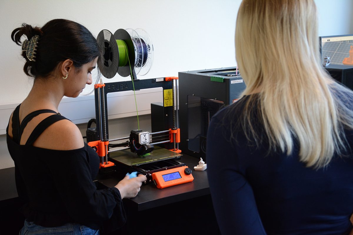 Elever framför en 3D-printer