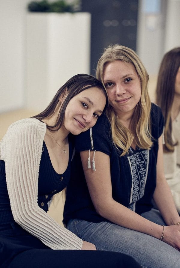 Två elever sitter i en skolkorridor