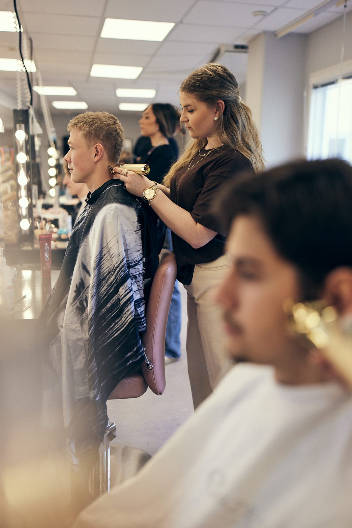 Elever trimmar hår i en salong