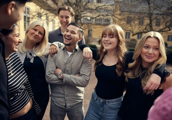 En grupp av elever står och skrattar