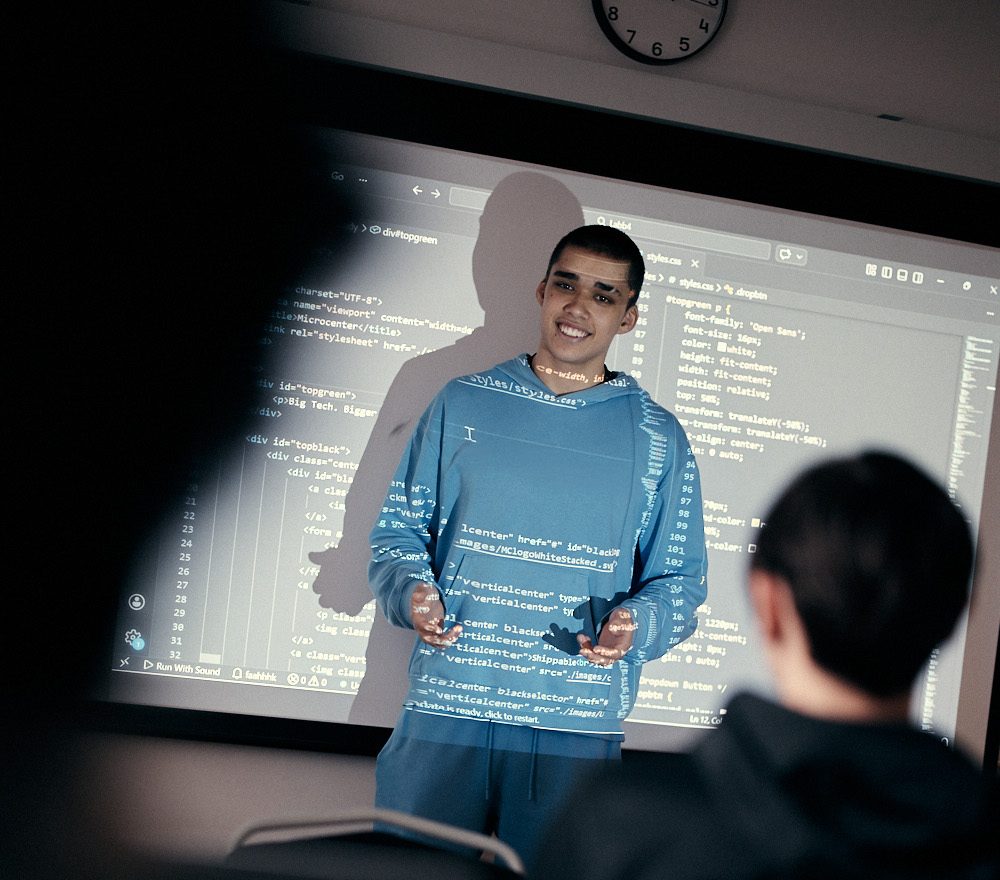 Elev i blå tröja som presenterar framför tavlan