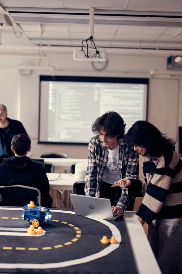 Två elever som kör en maskin på en bana med ankor