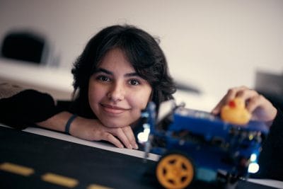 Elev som jobbar med en maskin med en anka ovanpå