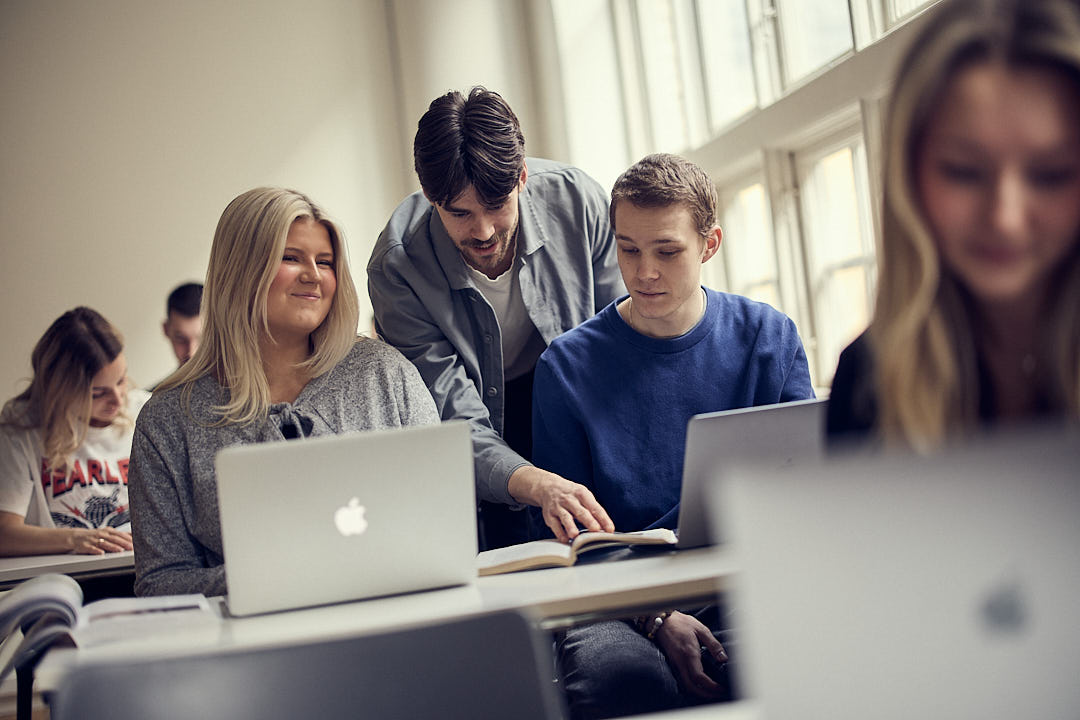 lärare hjälper två elever i ett klassrum