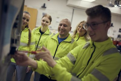 Lärare och elever i grupp med gula jackor