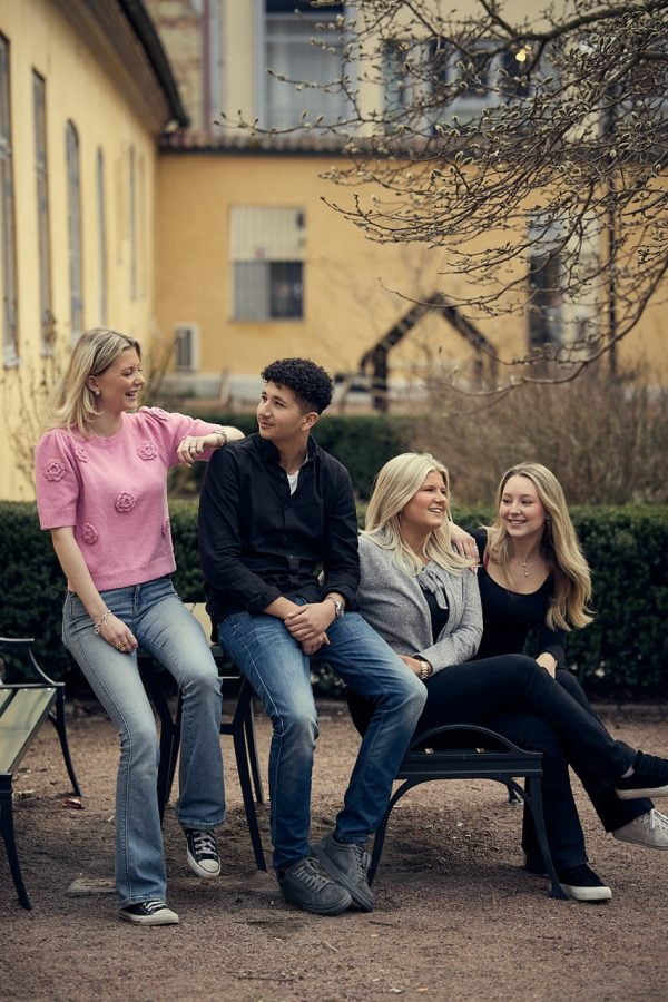 Fyra elever sitter på en bänk utanför skolan